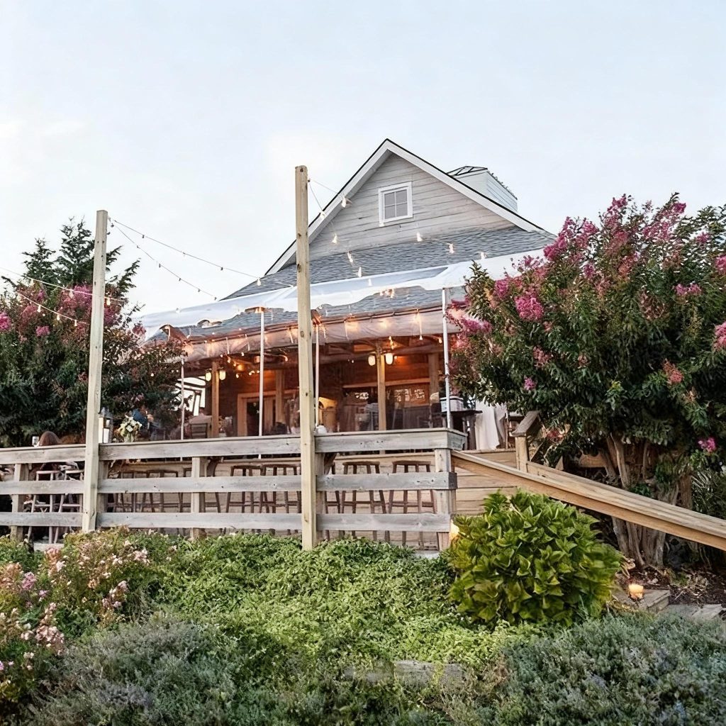 View of the Bedell Cellars house and tasting deck from the vineyard on the North Fork of Long Island during a private chauffeured wine tour.