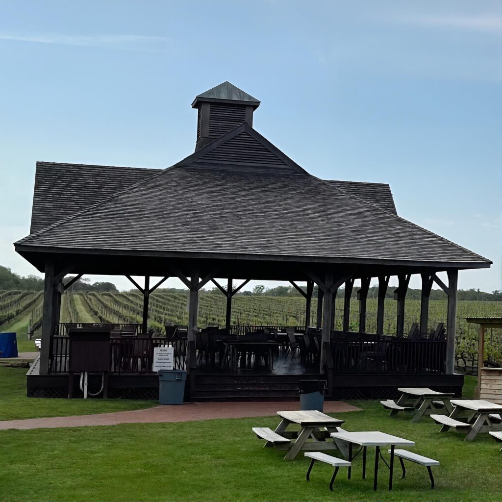 Wine tasting gazebo with tables set in front of the vineyard at Pindar Vineyards on the North Fork of Long Island during a private chauffeured wine tour.